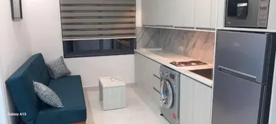 a small kitchen with a washing machine and a blue couch at غزو 15 in Irbid