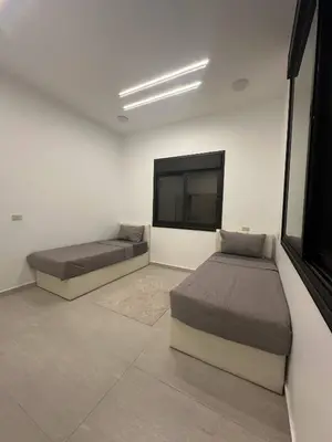 a bedroom with two beds and a flat screen tv at Luxury Haven villa in Jerash