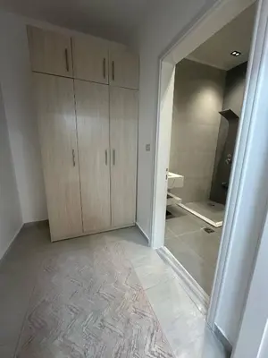 a bathroom with wooden cabinets and a mirror at Luxury Haven villa in Jerash