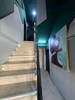 a staircase in a building with a painting on the wall at Cozy Studio in a Creative Hub in Amman
