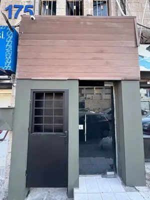 a building with a black door and a window at Cozy Studio in a Creative Hub in Amman