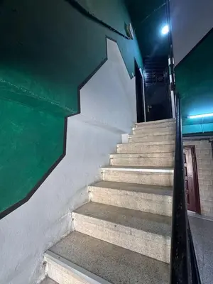 a staircase in a building with a green wall at Cozy Studio in a Creative Hub in Amman