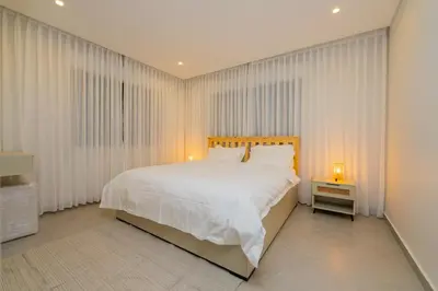 a bedroom with a large white bed and curtains at Maria Suites 2 in Aqaba