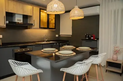 a kitchen with a island with chairs and a counter top at Maria Suites 1 in Aqaba