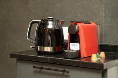 a black counter top with a coffee pot and a toaster at Maria Suites 1 in Aqaba