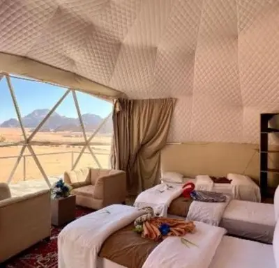 a room with three beds in a room with a window at Wadi Rum, the best stars in Wadi Rum