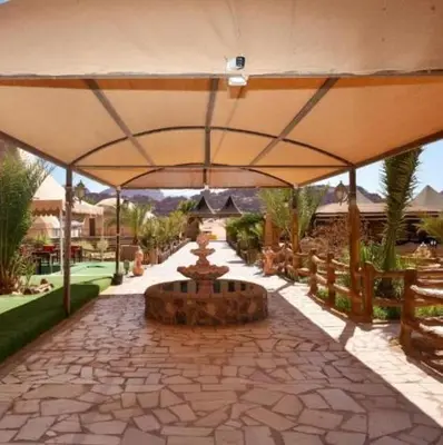 a patio with a large umbrella and a fountain at Wadi Rum, the best stars in Wadi Rum
