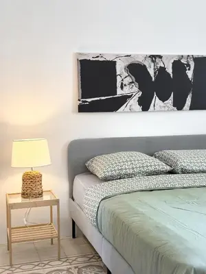 a bedroom with a bed and a table with a lamp at Turath by Badiya 2BR Apt In Luweibdeh in Amman