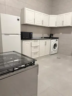 a kitchen with white cabinets and a washer and dryer at Turath by Badiya 2BR Apt In Luweibdeh in Amman