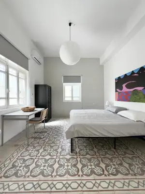 a bedroom with a bed and a table and a desk at Turath by Badiya 2BR Apt In Luweibdeh in Amman