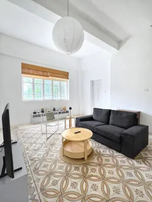 a living room with a black couch and a table at Turath by Badiya 2BR Apt In Luweibdeh in Amman