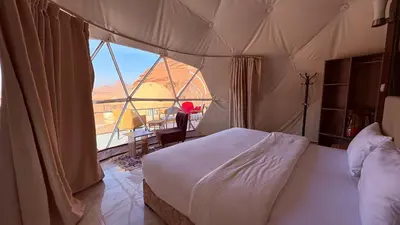 a bedroom with a bed and a large window at HAGIA SOPHIA lUXURY CAMP in Disah