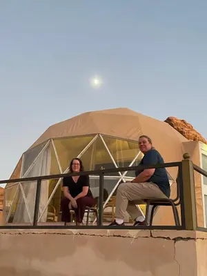 a man and woman sitting on a fence in a dome at HAGIA SOPHIA lUXURY CAMP in Disah