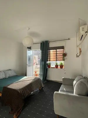 a bedroom with a bed and a couch and a window at Central apartment with beautiful view in Amman