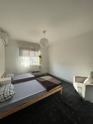 a bedroom with two beds and a chair at Central apartment with beautiful view in Amman