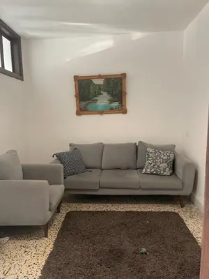a living room with a couch and a picture on the wall at Central apartment with beautiful view in Amman