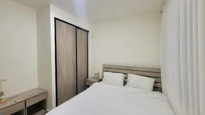 a bedroom with a white bed and a window at Lavender Résidence in Amman