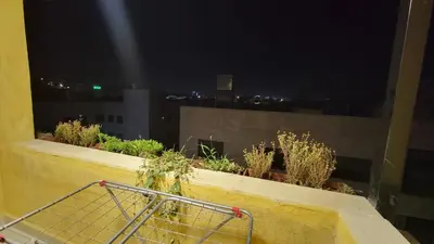 a shopping cart sitting on a balcony at night at Lavender Résidence in Amman