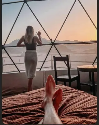 a woman standing on a bed in front of a window at RUM MAREA lUXURY CAMP in Wadi Rum