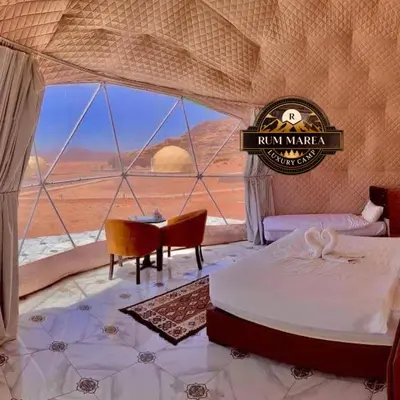 a bedroom with a bed and a view of the desert at RUM MAREA lUXURY CAMP in Wadi Rum