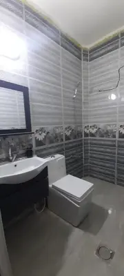 a bathroom with a toilet and a sink at Two Palms Housing in Jerash