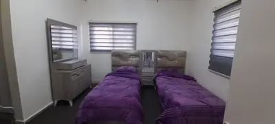 two beds in a room with purple blankets at Two Palms Housing in Jerash