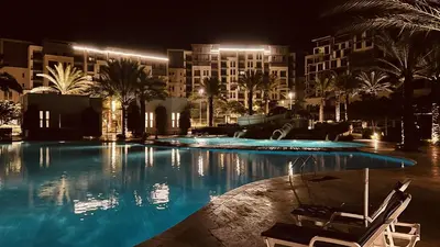 a swimming pool at night with a hotel at Luxury Suite in Aqaba AlRaha Village Marsa Zayed in Aqaba