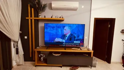 a flat screen tv sitting on top of a table at Luxury Suite in Aqaba AlRaha Village Marsa Zayed in Aqaba
