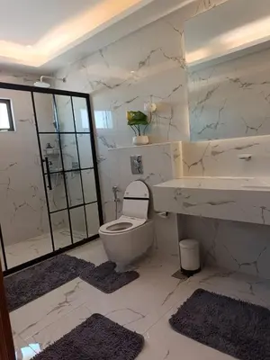 a white bathroom with a toilet and a sink at روف طابق ثاني تشطيب فندقي باطلاله ساحرة بعمارة عائلات بعبدون الشمالي in Amman