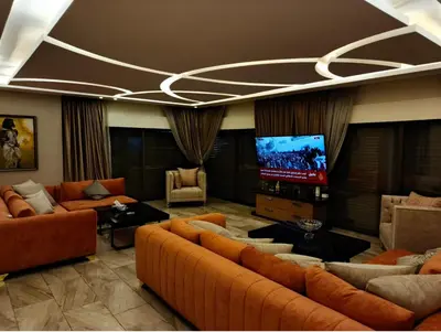 a living room with couches and a flat screen tv at روف طابق ثاني تشطيب فندقي باطلاله ساحرة بعمارة عائلات بعبدون الشمالي in Amman