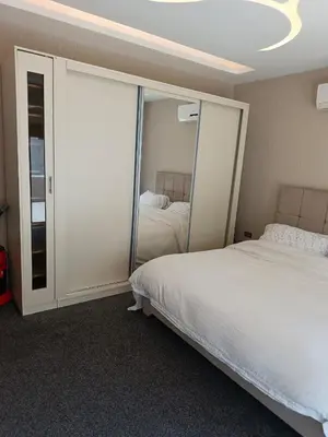 a bedroom with two beds and a sliding glass door at روف طابق ثاني تشطيب فندقي باطلاله ساحرة بعمارة عائلات بعبدون الشمالي in Amman