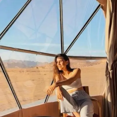 a woman sitting on a boat in the desert at Wadi Rum Karolina Bubbles camp in Wadi Rum
