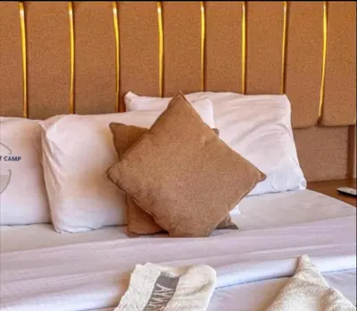 a bed with white pillows on it with at Wadi Rum Karolina Bubbles camp in Wadi Rum