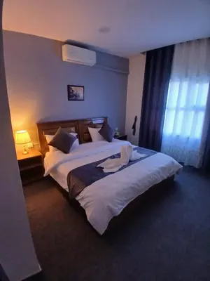 a hotel room with two beds and a window at Kahraman Amman Hotel in Amman