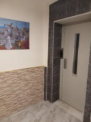 a bathroom with a painting on the wall and a door at Kahraman Amman Hotel in Amman