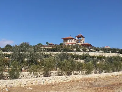 a house sitting on top of a hill with trees at Green Hills in Ajloun