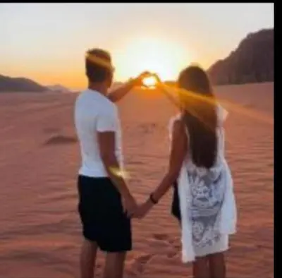 a man and a woman standing in the desert holding hands at Camb wadi Rum in Disah