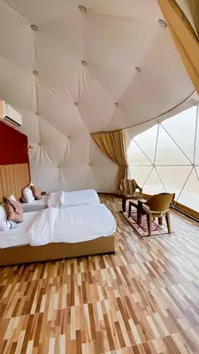 a room with a bed and a desk in a tent at Camb wadi Rum in Disah