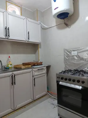 a kitchen with white cabinets and a stove top oven at Small huose in Amman