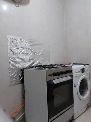 a kitchen with a stove and a washing machine at Small huose in Amman