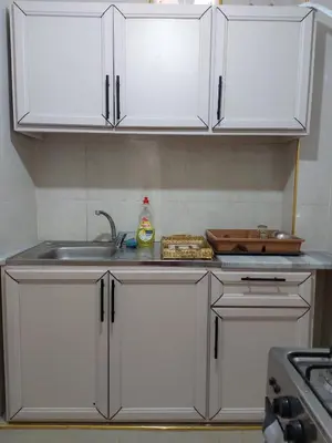 a kitchen with white cabinets and a sink at Small huose in Amman