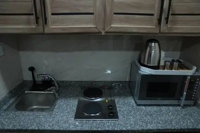a kitchen counter with a sink and a microwave at المتطورة للشقق الفندقية in Amman