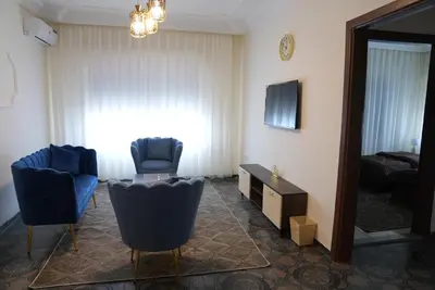 a living room with two chairs and a television in a room at المتطورة للشقق الفندقية in Amman