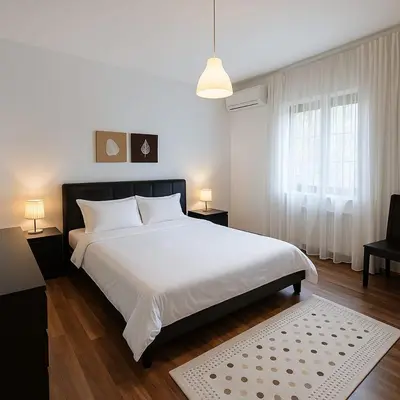 a bedroom with a large white bed and a window at Family Deluxe Apartment in Amman
