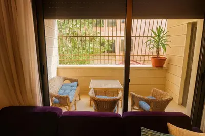 a patio with chairs and a table and a window at Family Deluxe Apartment in Amman