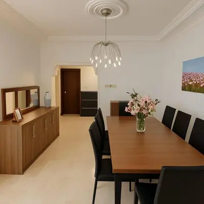 a dining room with a table and a vase of flowers at Family Deluxe Apartment in Amman