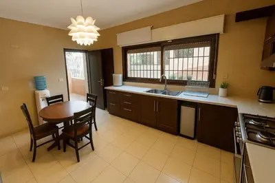 a kitchen with a wooden table and a dining room at Family Deluxe Apartment in Amman