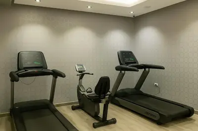 a gym with two elliptical machines and a phone at Elite Apartment Compound 1 in Amman