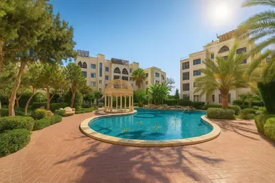 a swimming pool with a gazebo in front of a building at Elite Apartment Compound 1 in Amman