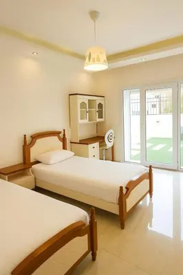 a bedroom with two beds and a large window at Elite Apartment Compound 1 in Amman